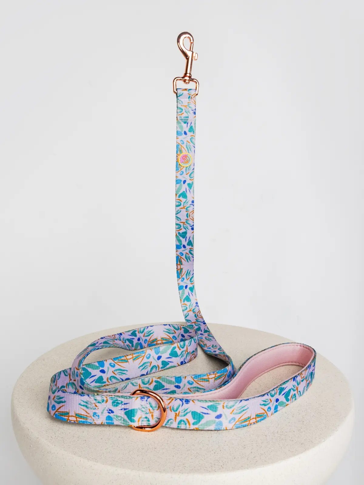 le-laisse-chic-pour-chien-le-chouchou Papillon Chic dog leash in turquoise floral design placed on a stone table – Le ChouChou Paris